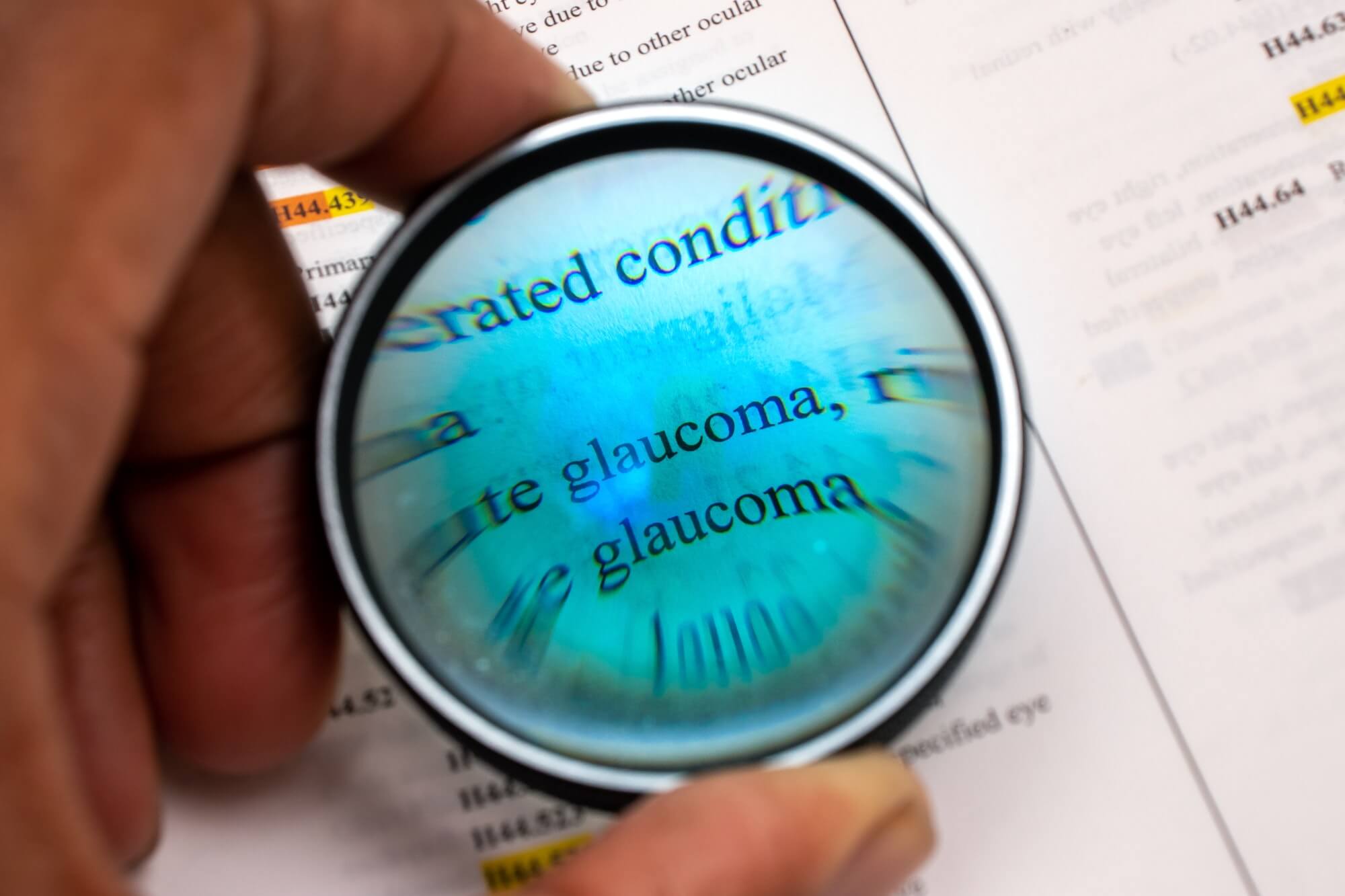 African American man using magnifying glass to look at word glaucoma